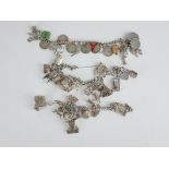 THREE VINTAGE SILVER CHARM BRACELETS Two bracelets having multiple novelty charms and one bracelet