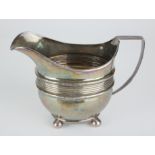 A GEORGIAN NEWCASTLE SILVER CREAM JUG Classical form on ball feet, hallmarked George Murray,