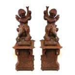 A PAIR 19TH CENTURY OF CAST IRON CHERUBS Standing on scroll worked plinths. (83cm x 43cm including