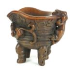 A CHINESE HORN LIBATION CUP Carved with a mythical beast. (h 13cm)