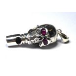 A NOVELTY SKULL FORM WHISTLE Having ruby set eyes. (approx 4cm)