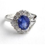 AN 18CT WHITE GOLD, SAPPHIRE AND DIAMOND RING The single oval cut sapphire edged with baguette and