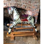 A LARGE MID 20TH CENTURY DAPPLE GREY ROCKING HORSE With leather and upholstered tac on pine base. (w