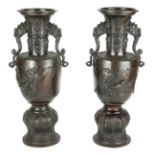 A PAIR OF 19TH CENTURY JAPANESE BRONZE MEJI VASES Having twin handles with embossed decoration of