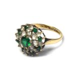 A 9CT GOLD WHITE SAPPHIRE AND EMERALD RING The arrangement of stones forming a daisy cluster (size