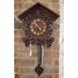 AN EARLY 20TH CENTURY CUCKOO CLOCK The architectural wooden case heavily applied with foliage.