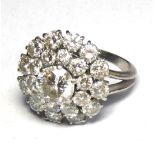 BOUCHERON, A PLATINUM AND DIAMOND CLUSTER RING The central round cut diamond edged with two rows