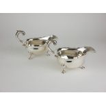 A RARE PAIR OF GEORGE II SILVER OVAL SAUCEBOATS With shaped rim and scrolled handle on stepped spade