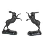 A PAIR OF BRONZE STATUES OF BOXING HARES Raised on a black marble base. (h 30cm)