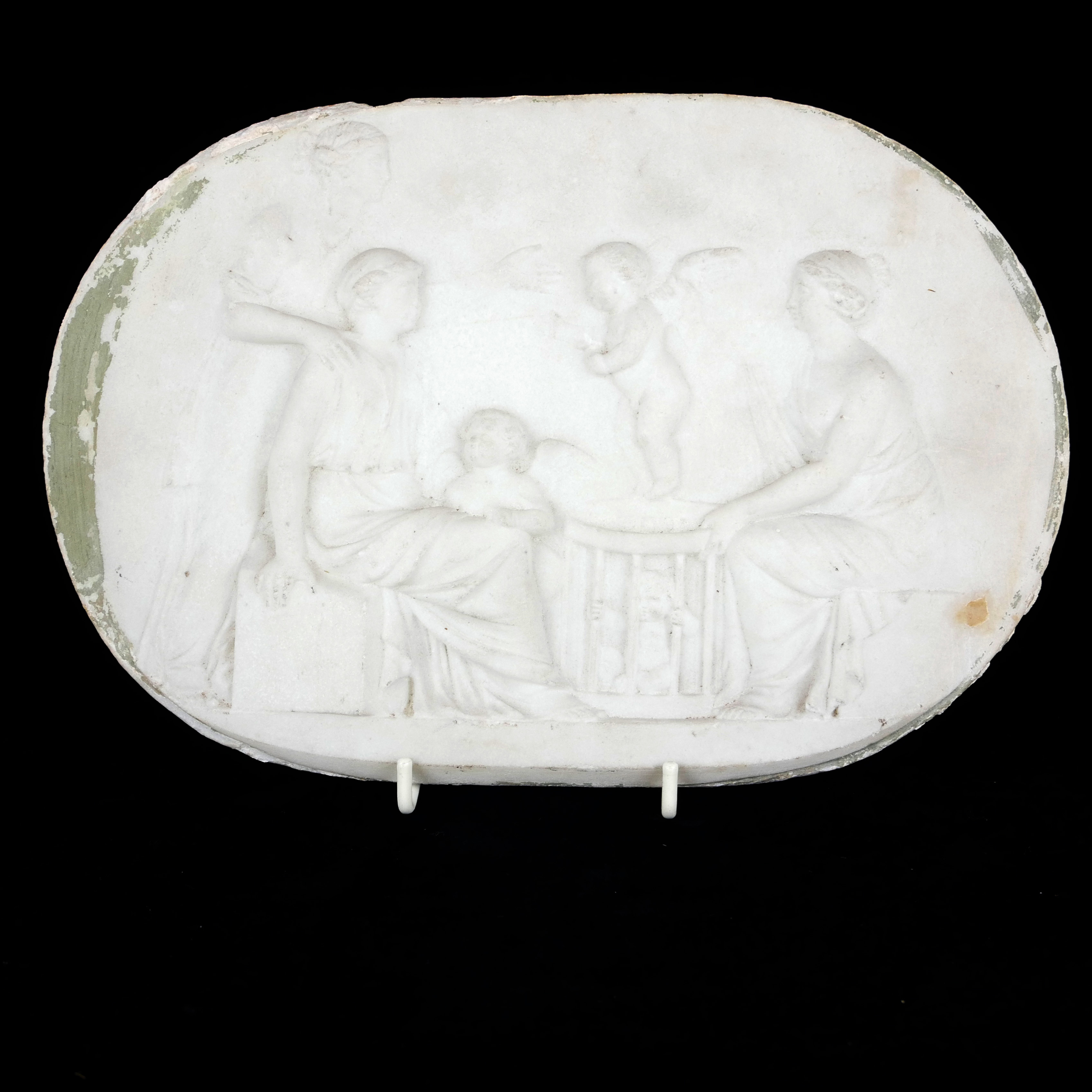 A 19TH CENTURY CARVED MARBLE OVAL PLAQUE Cherubs attending maidens. (27cm x 18cm)