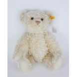 A VINTAGE BLOND MOHAIR STEIFF TEDDY BEAR Having elongated front paws and glass eyes, retaining