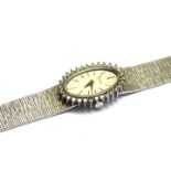 KUTCHINSKI, A CASED VINTAGE 18CT WHITE GOLD AND DIAMOND LADIES' WATCH Oval silver tone dial with