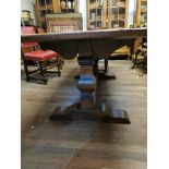 A SOLID OAK REFECTORY TABLE With thick top, raised on two square baluster columns. (198cm x 87cm x