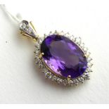 AN 18CT BICOLOUR GOLD, AMETHYST AND DIAMOND PENDANT Having a single oval cut amethyst edged with