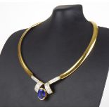 AN ITALIAN 18CT GOLD TANZANITE AND DIAMOND NECKLACE The oval cut tanzanite with an arrangement of