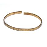 AN EARLY 20TH CENTURY GOLD PLATED SLAVE BANGLE Fine engraved decoration marked 'Metal Core'.