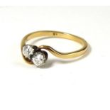 AN EARLY 20TH CENTURY 18CT AND DIAMOND TWO STONE RING Circular cut stones in a half twist mount (