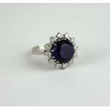 A 14CT WHITE GOLD, AMETHYST AND DIAMOND RING The single faceted round cut amethyst edged with