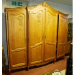 AN EARLY/MID 20TH CENTURY DUTCH OAK TRIPLE BREAKFRONT WARDROBE The shaped cornice centred with a