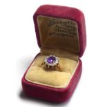 A 9CT GOLD AMETHYST AND PASTE RING The oval cut amethyst edged in paste stones. (size O/P)