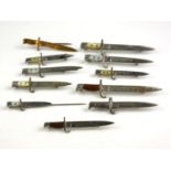 A COLLECTION OF ELEVEN WWI MINIATURE BAYONET BATTLE BROOCHES Having mother of pearl handles and