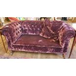 A VICTORIAN DROP END CHESTERFIELD SETTEE Button back purple velvet upholstery, raised on turned legs