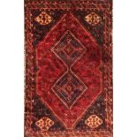 A BOKHARA WOOLLEN RUG Having two rows of five geometric form guls on a dark red field, contained