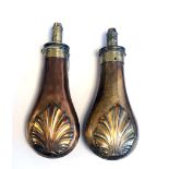 A MATCHED PAIR OF 19TH CENTURY BRASS AND COPPER POWDER FLASKS With relief shell decoration. (20cm)