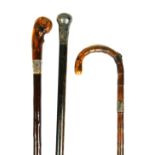 AN ANTIQUE SILVER TOPPED WALKING STICK Along with three silver collared sticks. (89cm)