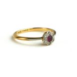 AN 18CT GOLD, DIAMOND AND RUBY DAISY CLUSTER RING The single round cut ruby edged with diamonds (