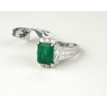 AN 18CT WHITE GOLD EMERALD AND DIAMOND RING Having a single baguette cut emerald, edged with round