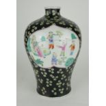 A CHINESE FAMILLE VERT BALUSTER PORCELAIN VASE With figures in an exotic garden on black ground. (