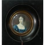 A 19TH CENTURY CIRCULAR MINIATURE PORTRAIT OF A YOUNG LADY Wearing a two strand pearl necklace,