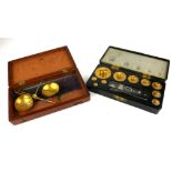 A CASED SET OF EARLY 20TH CENTURY CIRCULAR BRASS WEIGHTS Marked 200g - 10mg, in fitted black