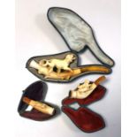 THREE CASED MEERSCHAUM PIPES Carved with animal figures. (largest 18cm)