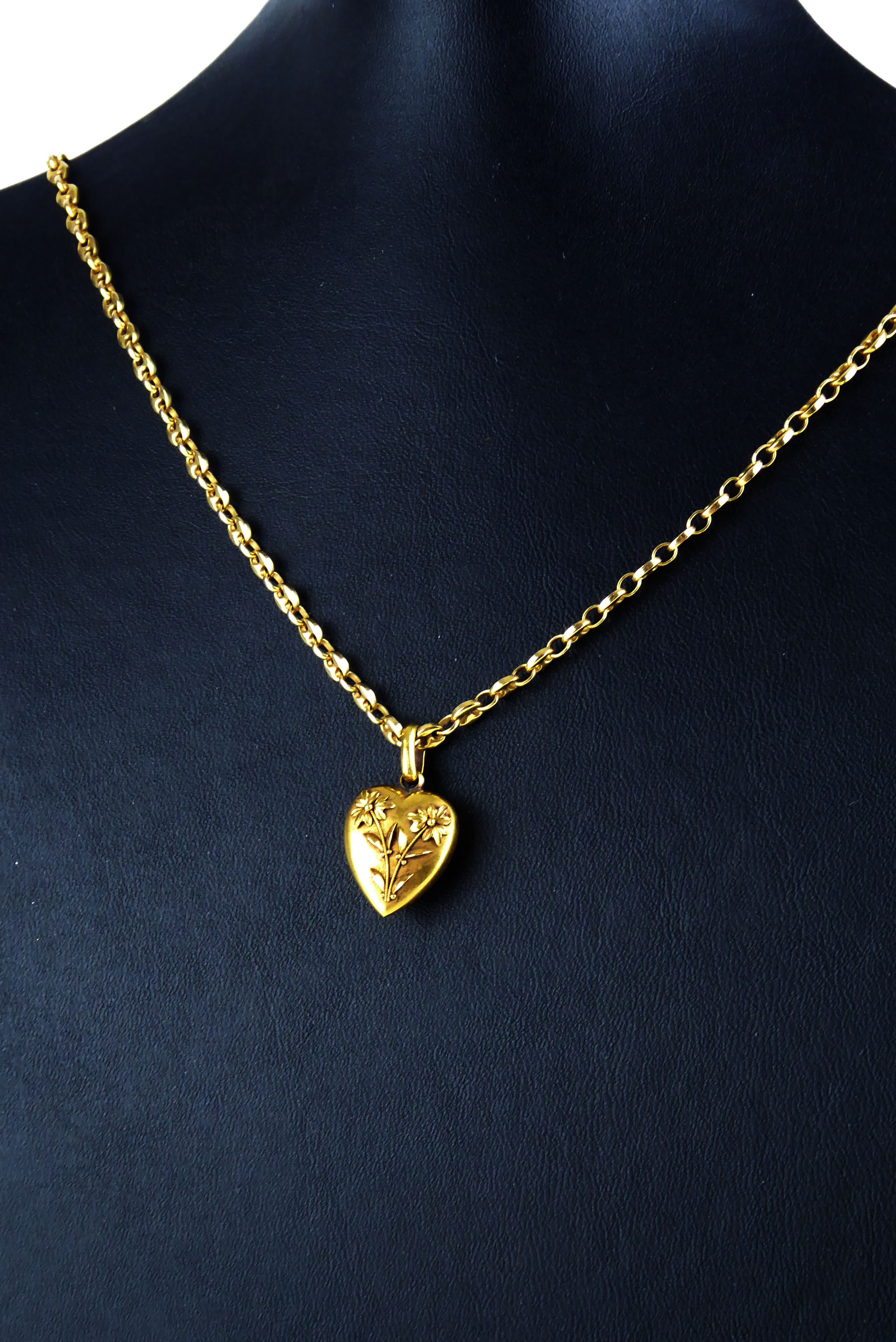 A VICTORIAN 15CT GOLD HEART FORM PENDANT AND 9CT GOLD NECKLACE Having applied floral decoration on a