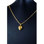 A VICTORIAN 15CT GOLD HEART FORM PENDANT AND 9CT GOLD NECKLACE Having applied floral decoration on a