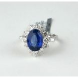 AN 18CT WHITE GOLD, SAPPHIRE AND DIAMOND RING Having an oval cut sapphire edged with round cut