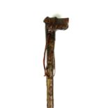 AN EARLY 20TH CENTURY WALKING STICK The carved handle in the form of a scotty dog with glass