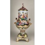 A CAPODIMONTE VASE AND COVER Decorated in relief with a Bacchanalian feast. (43cm)