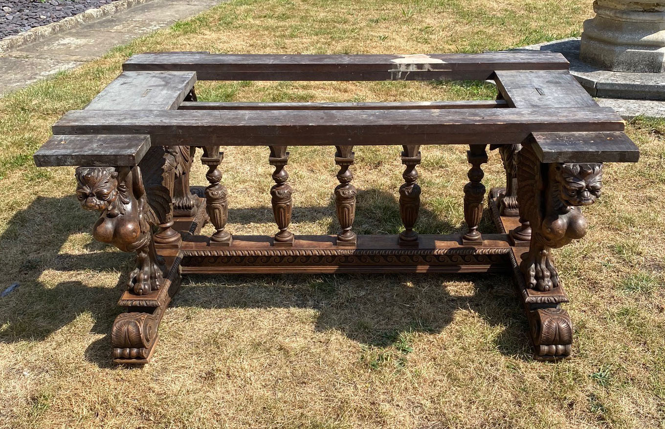 A 19TH CENTURY OAK TABLE BASE With heavily carved supports in the form of four winged griffins. (
