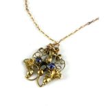 AN ART NOUVEAU YELLOW METAL AND SAPPHIRE PENDANT Having two sapphires in pierced organic form mount,