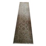 A ZIEGLER RUNNER With central floral field, contained in running borders on a beige ground. (78cm