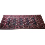 AN AZERBAIJANI WOOLLEN RUG With fifteen central lozenges contained in running borders. (132cm x