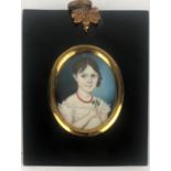 A 19TH CENTURY OVAL MINIATURE NAIVE SHOOL PORTRAIT Young lady wearing a coral necklace and holding a
