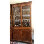 A REGENCY STYLE YEW DISPLAY CABINET With dentil cornice above two glazed doors and cupboards. (113cm