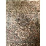 A FINE AND LARGE AGRA RUG OF TRADITIONAL MOGUL DESIGN Pale greens and red on a beige field. (197cm x