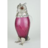 A SILVER PLATED CRANBERRY GLASS CLARET JUG IN THE FORM OF AN OWL With clear glass handle. (h 29cm)
