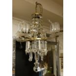 AN EARLY 20TH CENTURY FOUR BRANCH CHANDELIER Hung with crystal prism drops. (66cm)