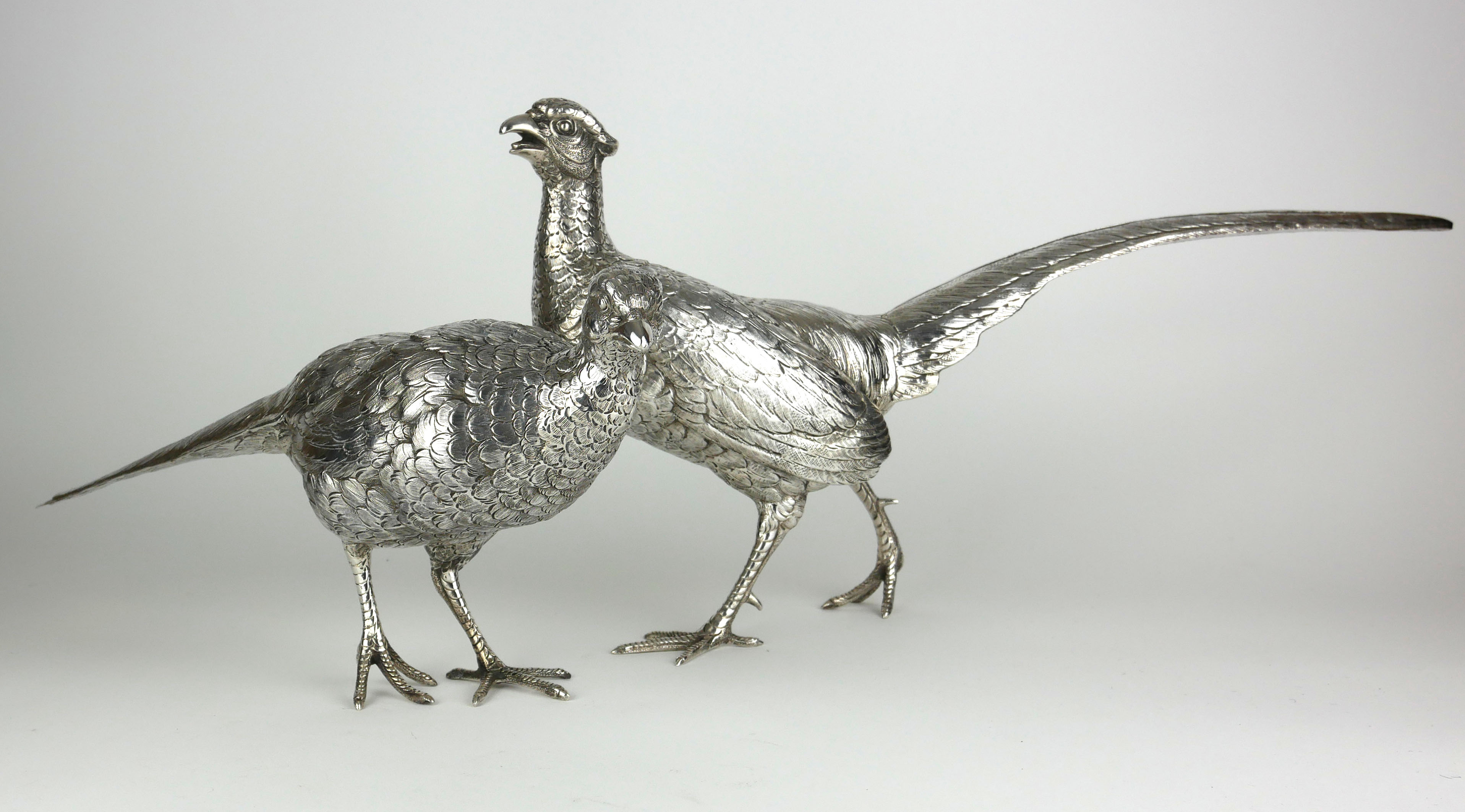 A PAIR OF CONTINENTAL SILVER PHEASANTS Male and female birds with fine detailed engraved decoration,